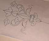 Drawing a floral design on paper.
